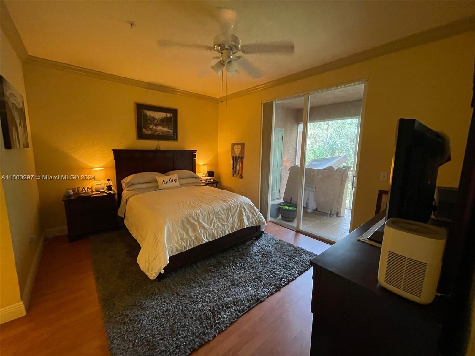 6830 West Sample Road, Unit 6830 Coral Springs, FL 33067 - Photo 10 of 30 a bedroom with a bed and wooden floor