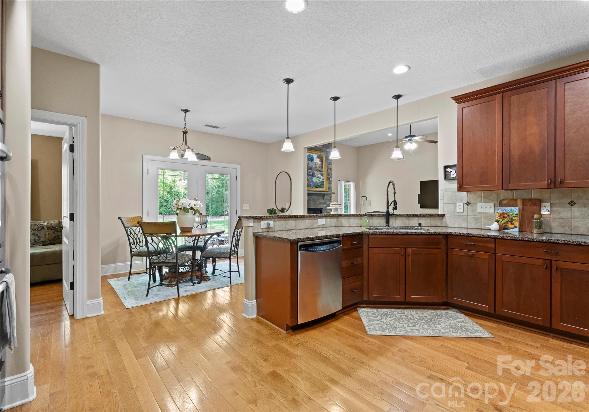 860 Arrow Point Lane Kannapolis, NC 28081 - Photo 15 of 38 a kitchen with stainless steel appliances granite countertop a refrigerator a sink dishwasher a dining table and chairs with wooden floor