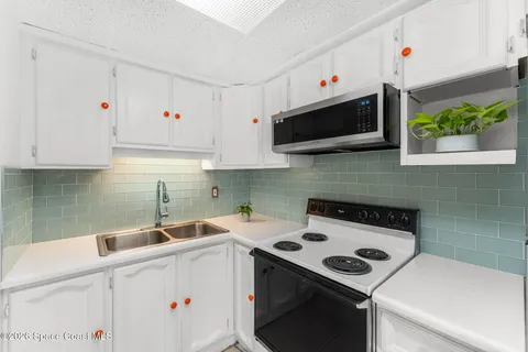 a kitchen with a refrigerator and a stove top oven