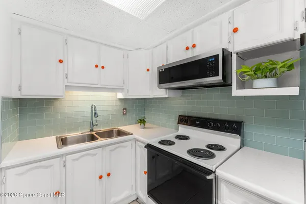 a kitchen with a refrigerator and a stove top oven
