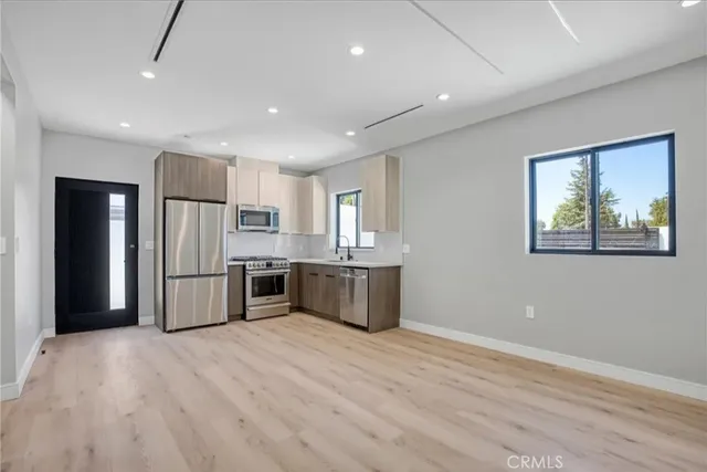 a kitchen with stainless steel appliances a refrigerator and a stove top oven