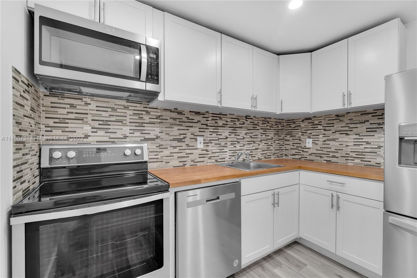 6920 Harding Avenue, Unit 502 Miami Beach, FL 33141 - Photo 21 of 39 a kitchen with cabinets stainless steel appliances and a sink