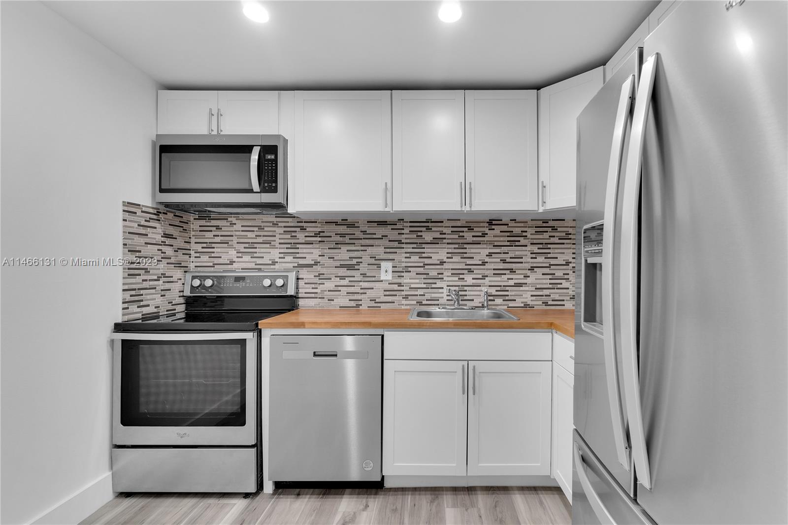 6920 Harding Avenue, Unit 502 Miami Beach, FL 33141 - Photo 22 of 39 a kitchen with white cabinets and stainless steel appliances