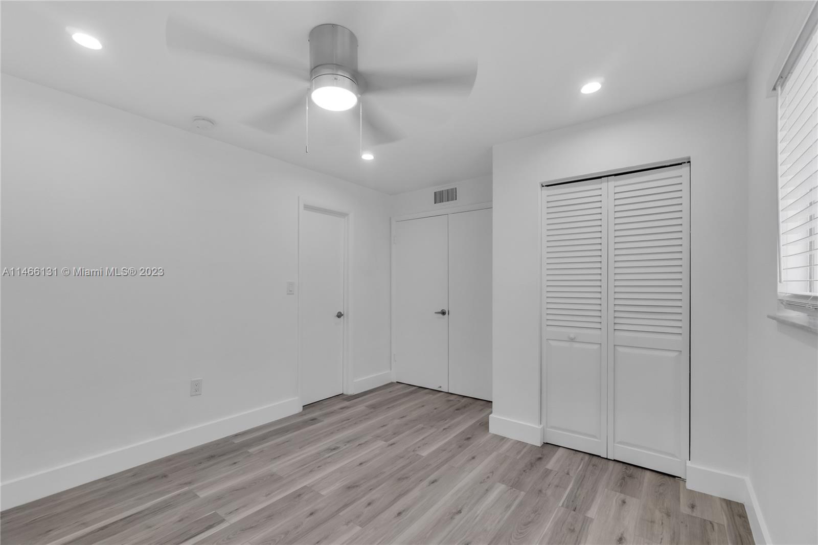6920 Harding Avenue, Unit 502 Miami Beach, FL 33141 - Photo 28 of 39 an empty room with wooden floor and windows
