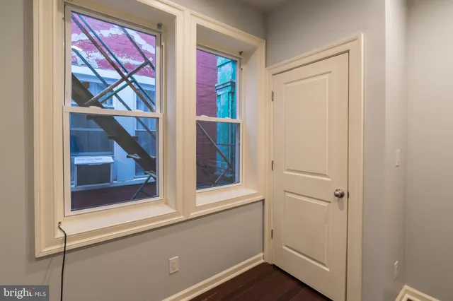 a view of empty room with wooden floor