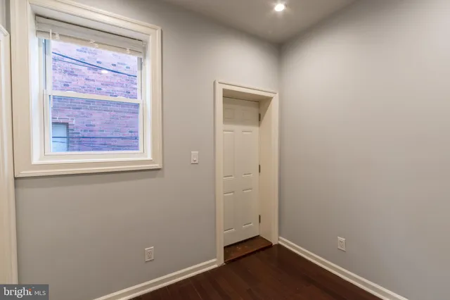an empty room with wooden floor and a window