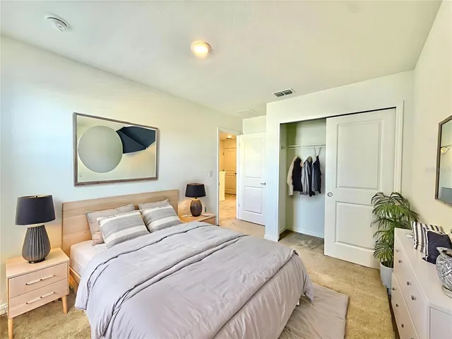a bedroom with a bed and a potted plant