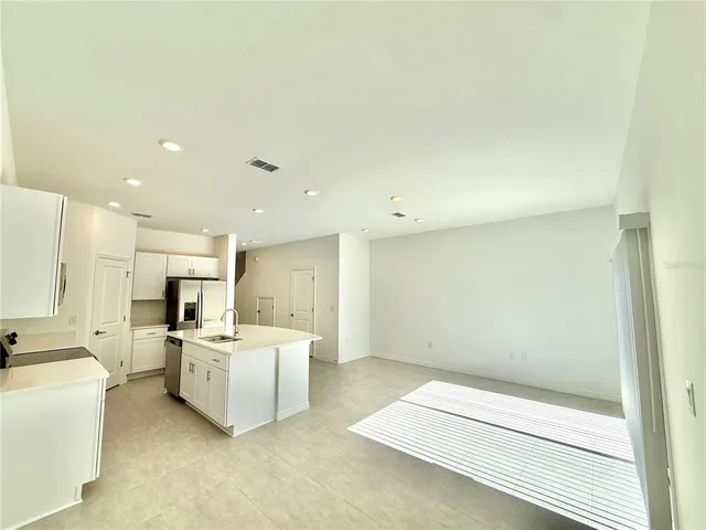 a large white kitchen with cabinets