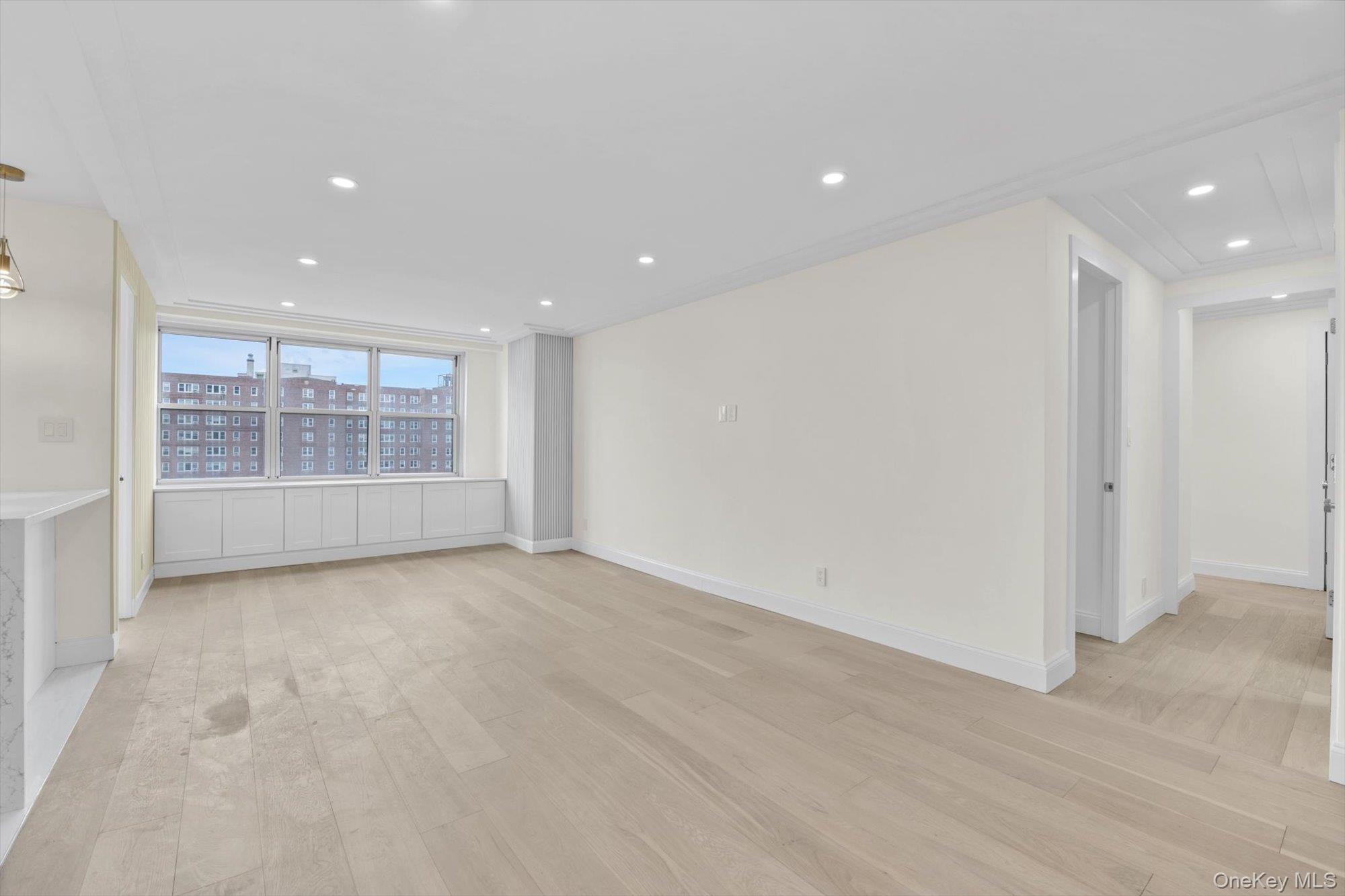 555 Kappock Street, Unit 12G Bronx, NY 10463 - Photo 5 of 19 an empty room with wooden floor and windows