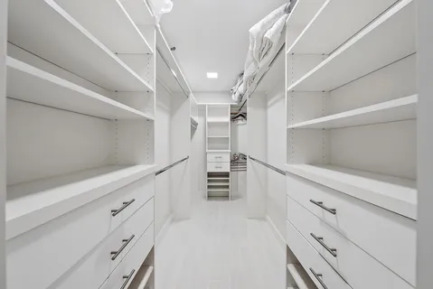 a view of walk in closet with empty racks