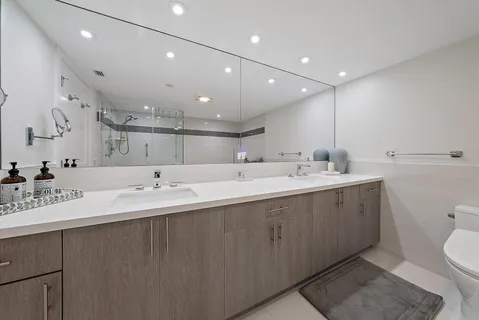 a large bathroom with a double vanity sink mirror and toilet