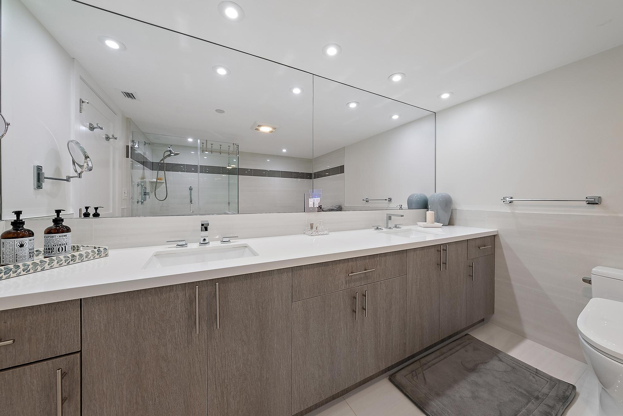 5070 North Ocean Drive, Unit 5B Riviera Beach, FL 33404 - Photo 12 of 37 a large bathroom with a double vanity sink mirror and toilet