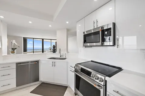 a large kitchen with a large window and stainless steel appliances