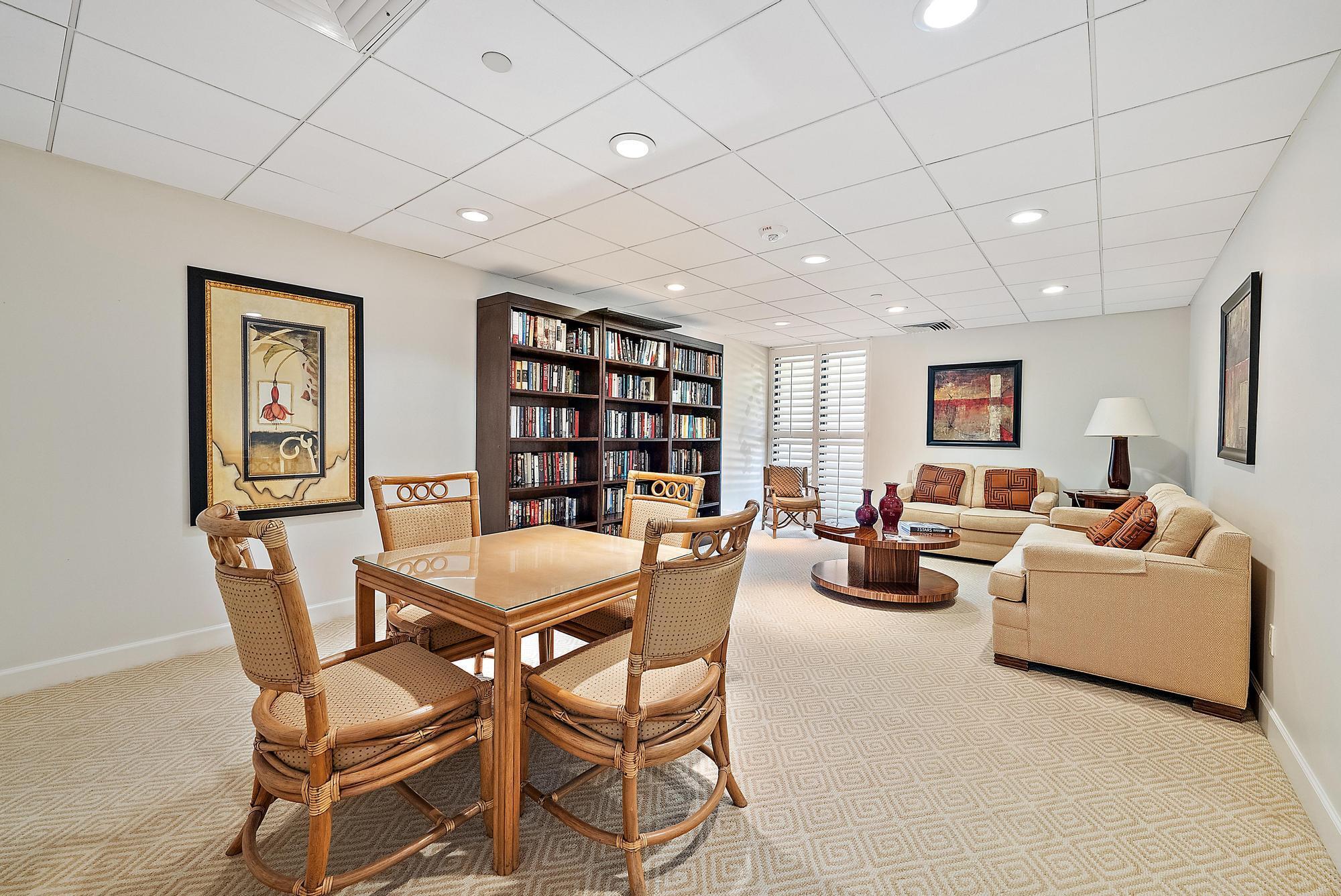5070 North Ocean Drive, Unit 5B Riviera Beach, FL 33404 - Photo 26 of 37 a living room with furniture and a book shelf