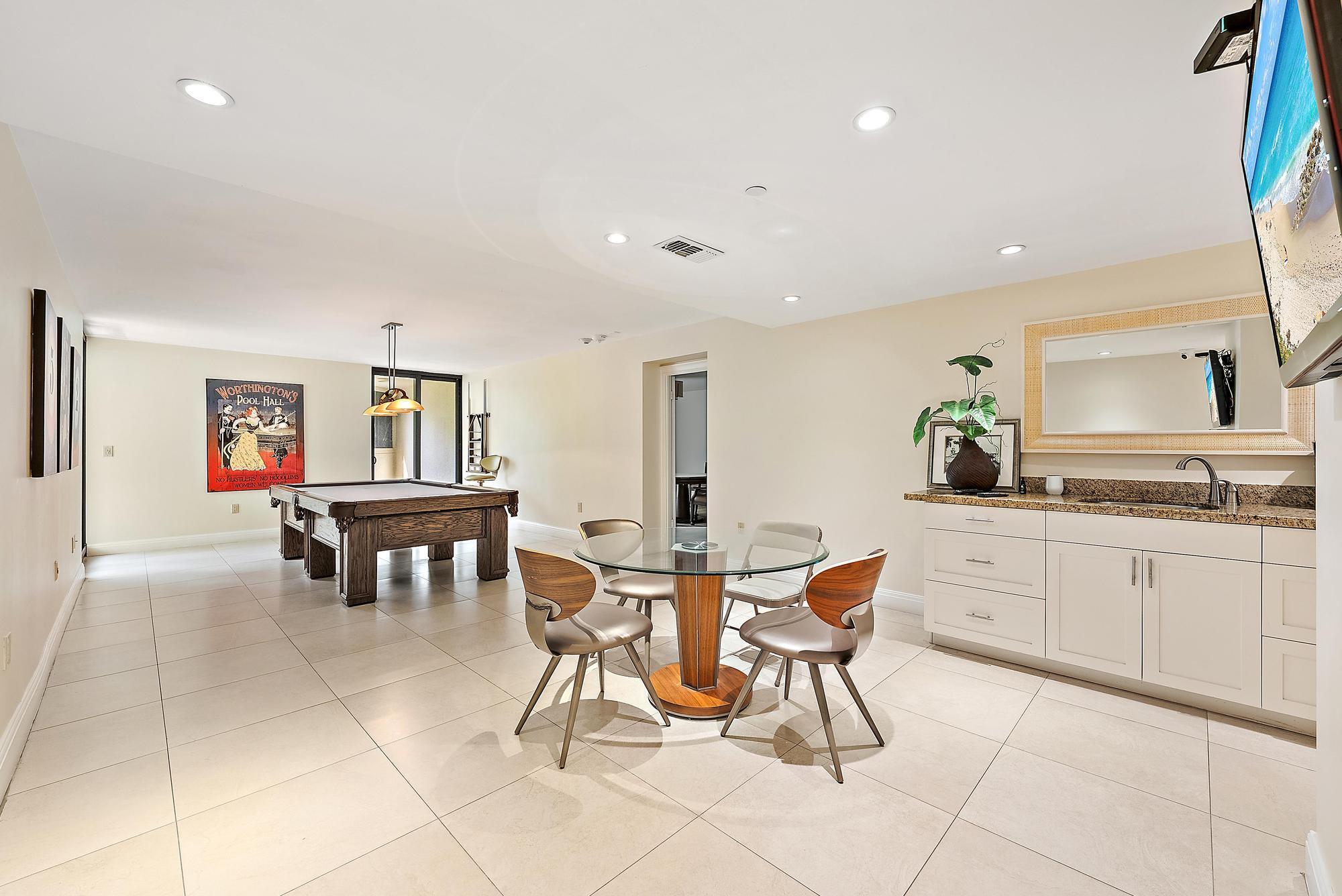 5070 North Ocean Drive, Unit 5B Riviera Beach, FL 33404 - Photo 29 of 37 a kitchen with stainless steel appliances kitchen island granite countertop a table and chairs in it
