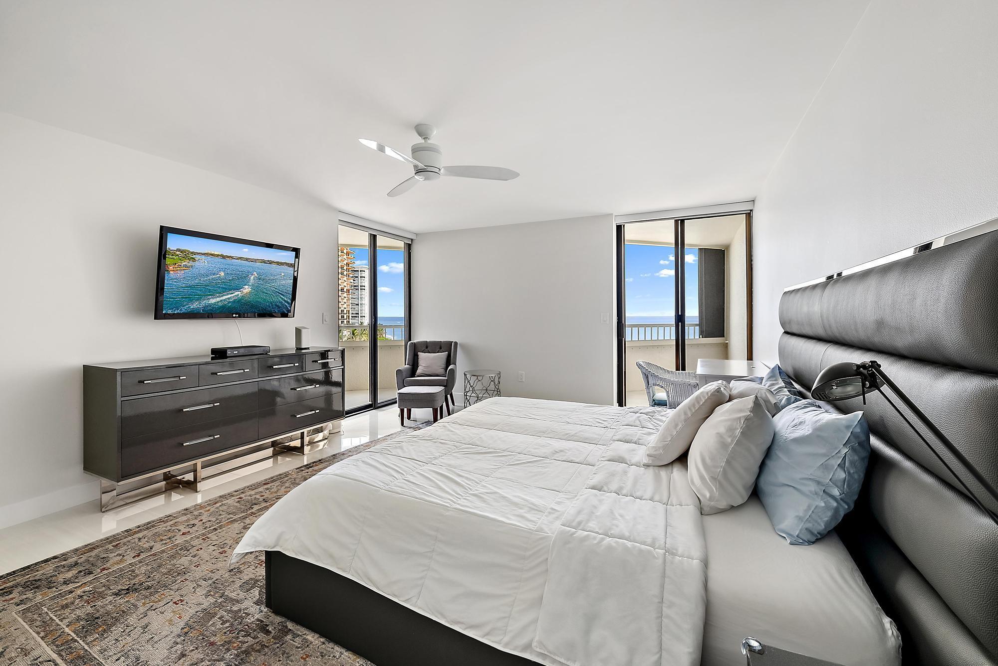 5070 North Ocean Drive, Unit 5B Riviera Beach, FL 33404 - Photo 10 of 37 a bedroom with a bed and a flat screen tv