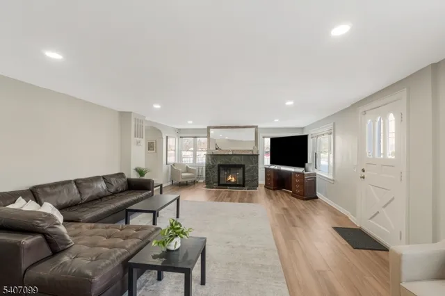 a living room with furniture a fireplace and a flat screen tv