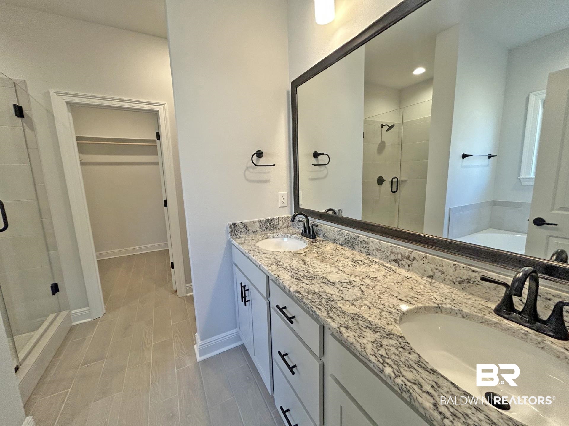 1748 Breckinridge Place Foley, AL 36535 - Photo 14 of 25 Bathroom with a stall shower, wood finish floors, a spacious closet, double vanity, and a bath