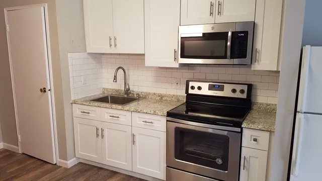 a kitchen with stainless steel appliances granite countertop a stove and a microwave