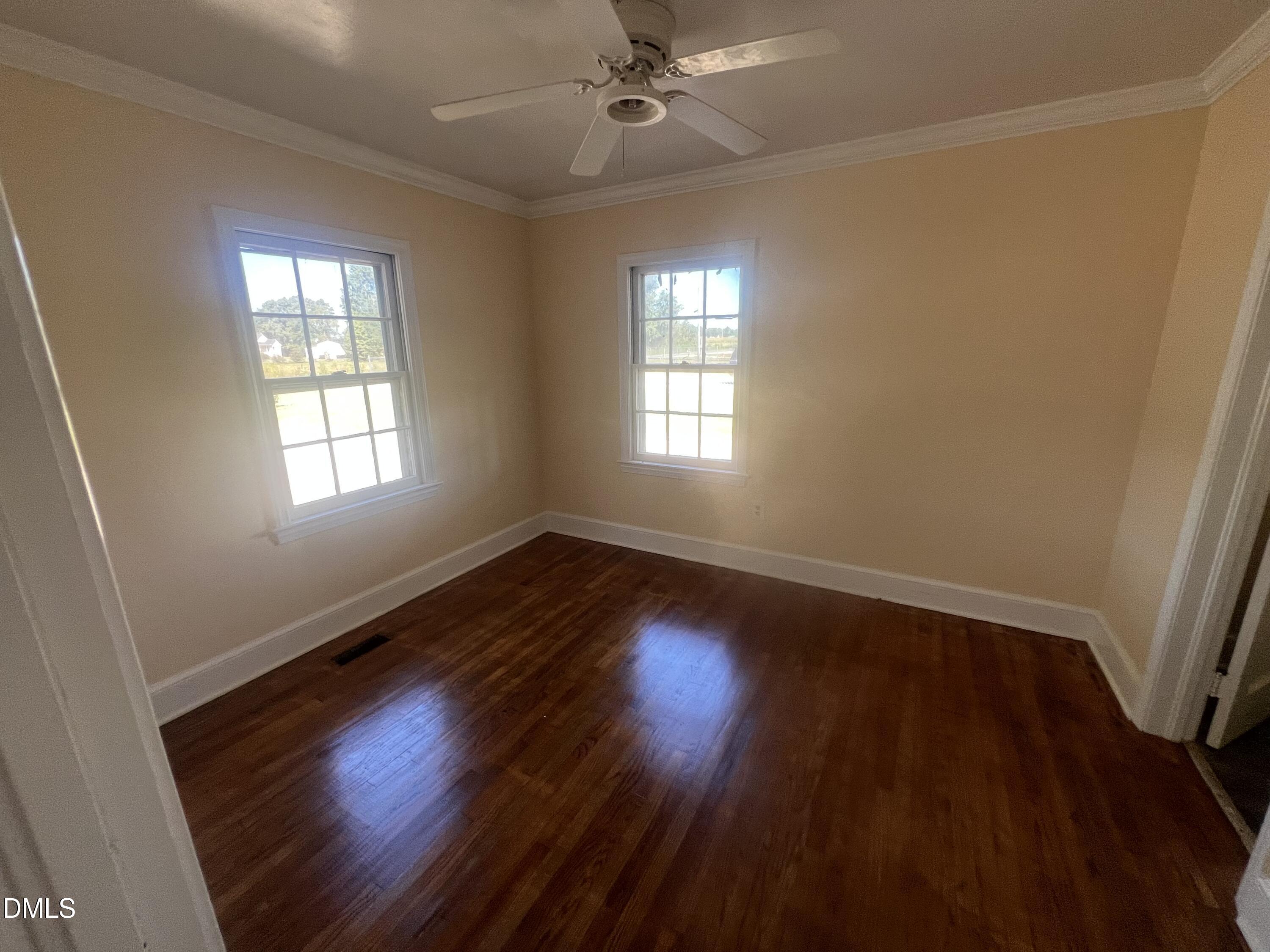 122 Bill Avery Road Coats, NC 27521 - Photo 14 of 51 a view of an empty room with wooden floor and a window