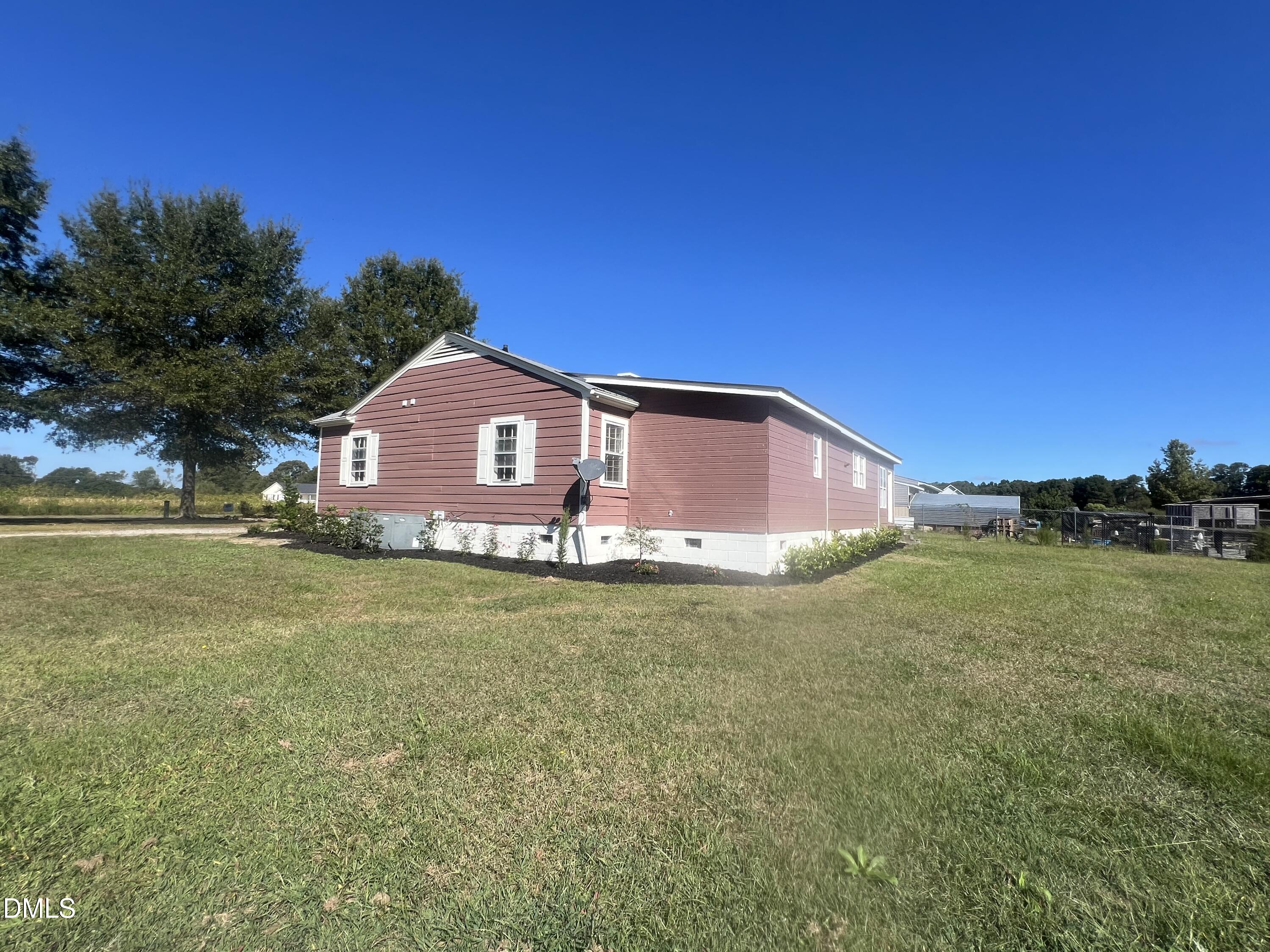 122 Bill Avery Road Coats, NC 27521 - Photo 4 of 51 a front view of a house with a garden and yard