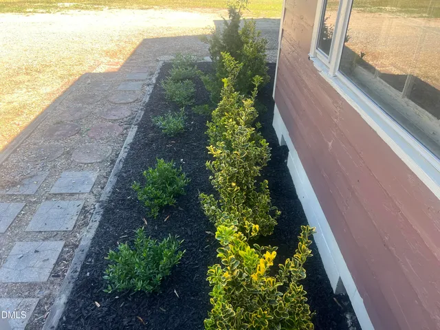 a front view of a house with a yard and a garden