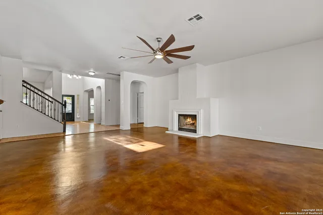 an empty room with windows and fireplace