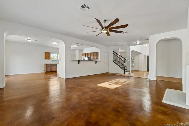 a view of a kitchen with kitchen island a counter top space a sink stainless steel appliances and cabinets