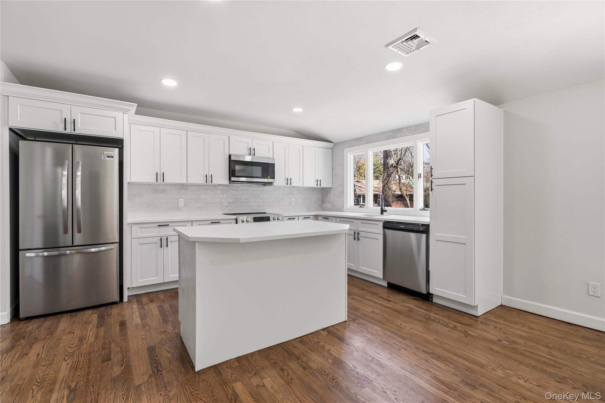 75 Hawthorne Road Kings Park, NY 11754 - Photo 13 of 34 a kitchen with a refrigerator stove and wooden cabinets