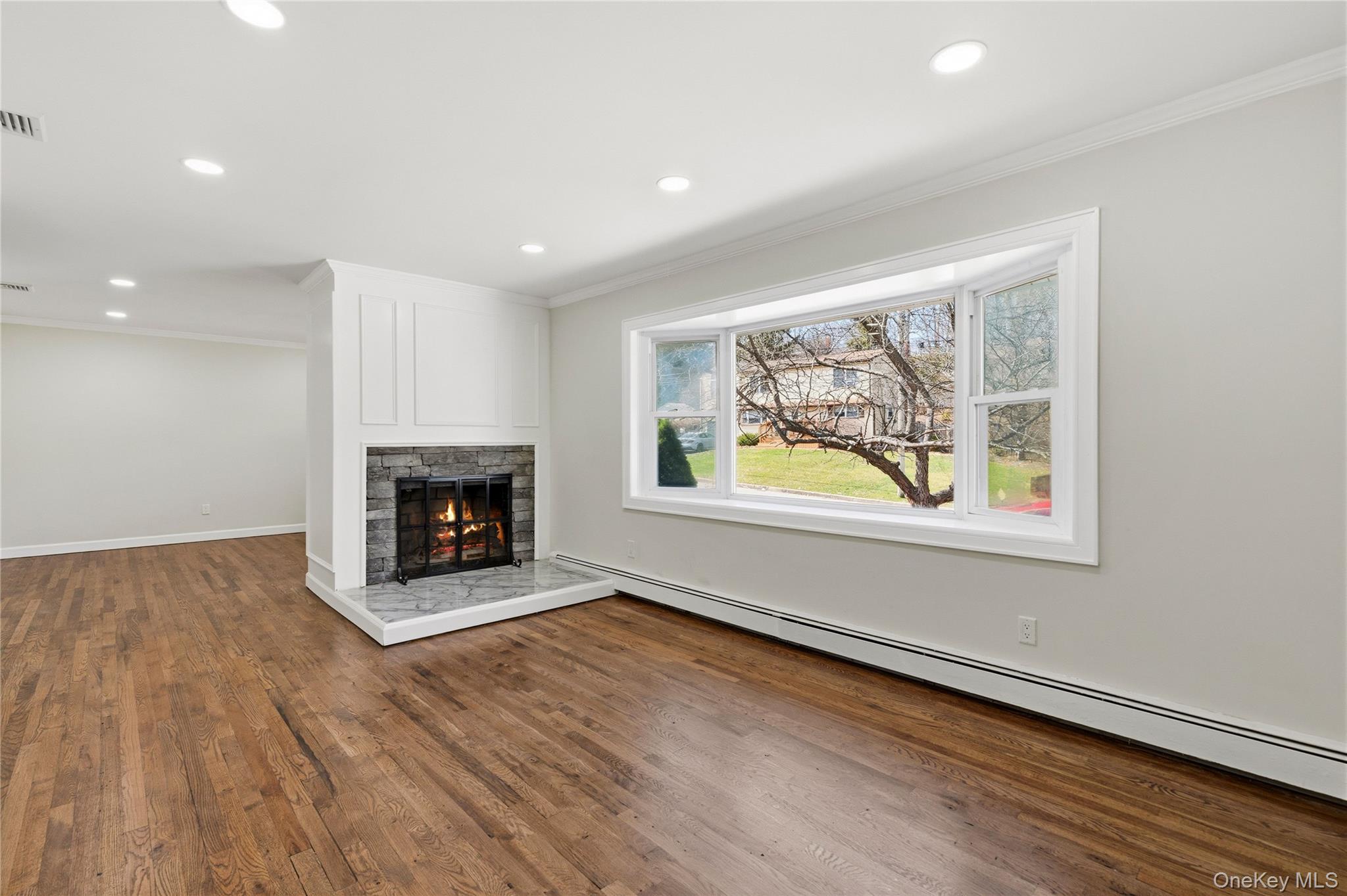 75 Hawthorne Road Kings Park, NY 11754 - Photo 4 of 34 an empty room with wooden floor fireplace and windows