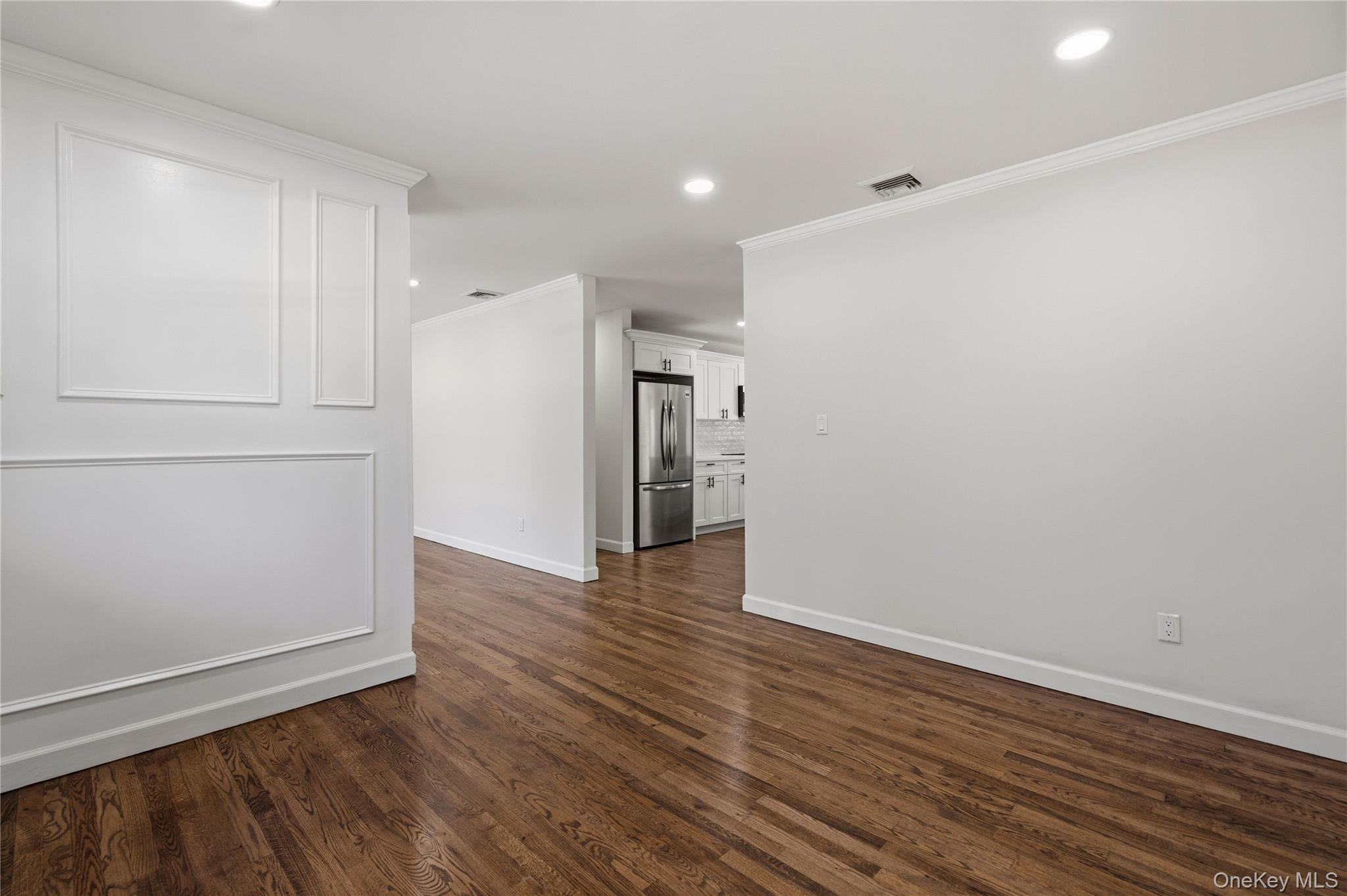 75 Hawthorne Road Kings Park, NY 11754 - Photo 7 of 34 a view of an empty room with wooden floor and a refrigerator