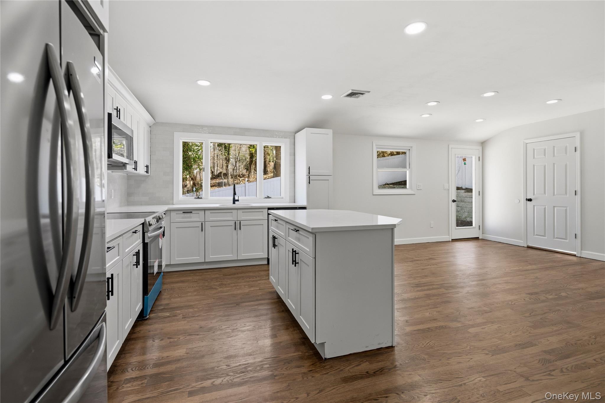 75 Hawthorne Road Kings Park, NY 11754 - Photo 8 of 34 a large kitchen with stainless steel appliances granite countertop a large counter top a sink a refrigerator and a window