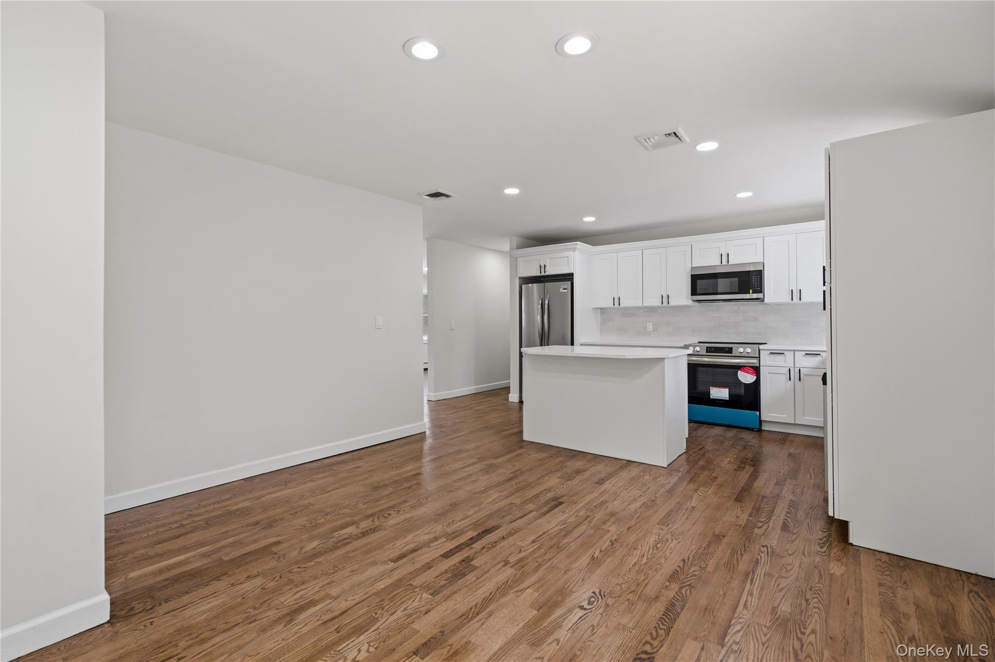 75 Hawthorne Road Kings Park, NY 11754 - Photo 10 of 34 a view of kitchen with kitchen island wooden floors and stainless steel appliances
