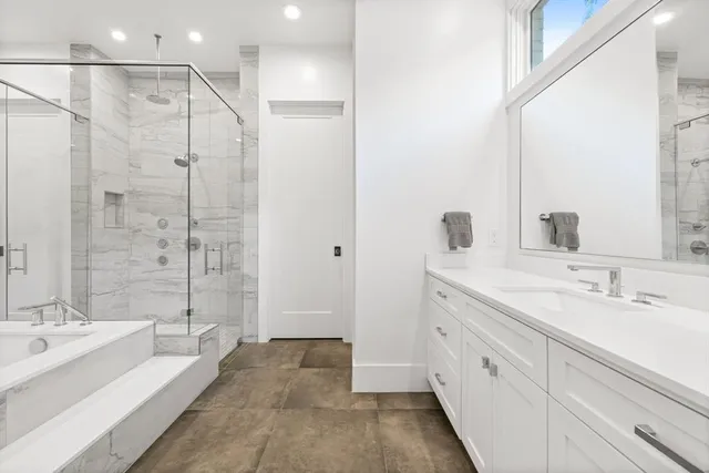 a spacious bathroom with a shower sink double vanity and mirror