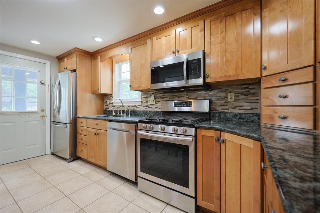 20 Kent Street Saugus, MA 01906 - Photo 6 of 41 a kitchen with stainless steel appliances granite countertop a stove a sink and a microwave