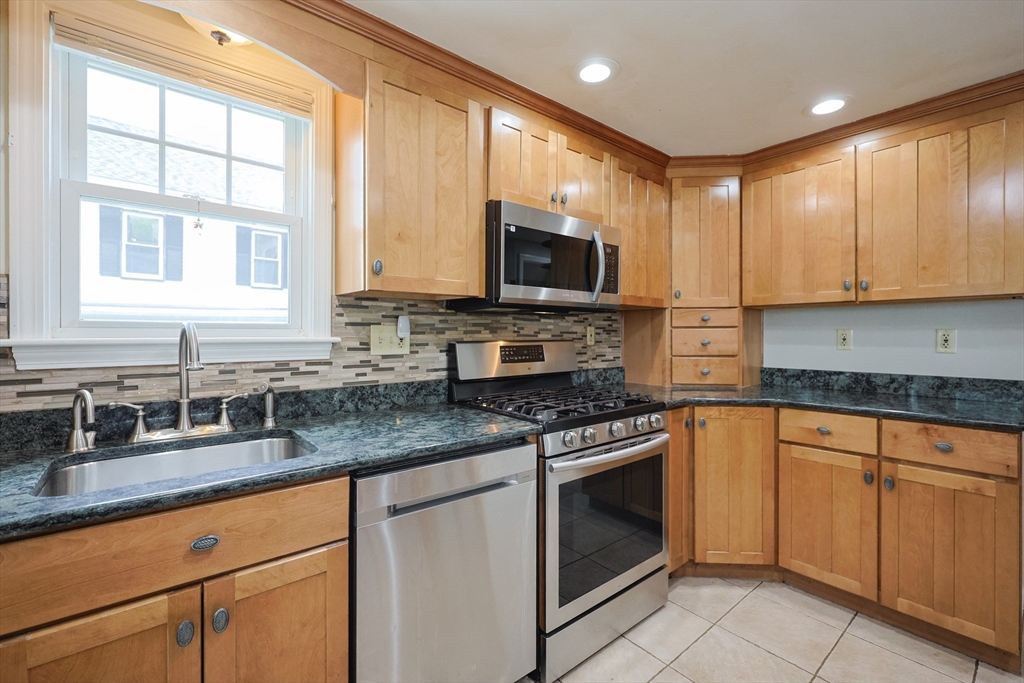 20 Kent Street Saugus, MA 01906 - Photo 7 of 41 a kitchen with stainless steel appliances granite countertop white cabinets granite counter tops and a window