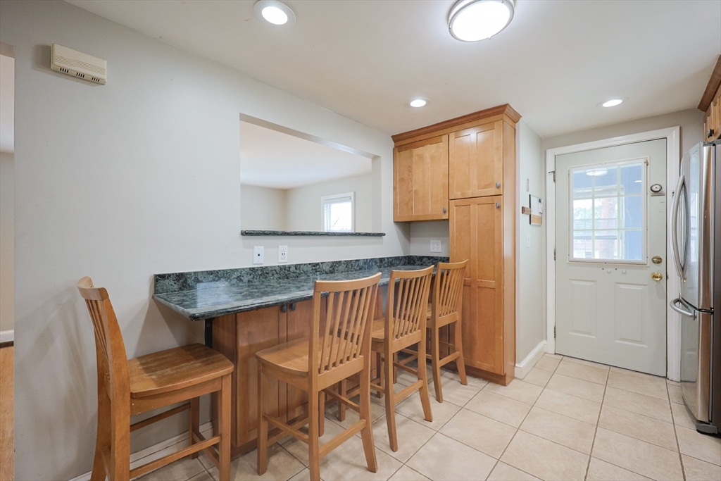 20 Kent Street Saugus, MA 01906 - Photo 8 of 41 a kitchen with granite countertop chairs and refrigerator