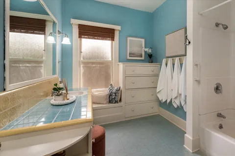 a bathroom with a tub sink and mirror