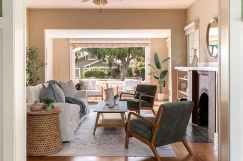a living room with fireplace furniture and a large window
