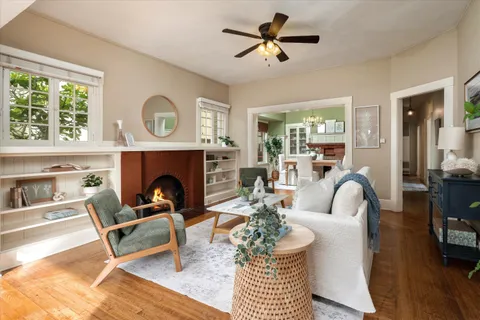 a living room with furniture a fireplace and a large window
