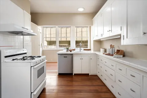 a kitchen with cabinets appliances a sink and a window
