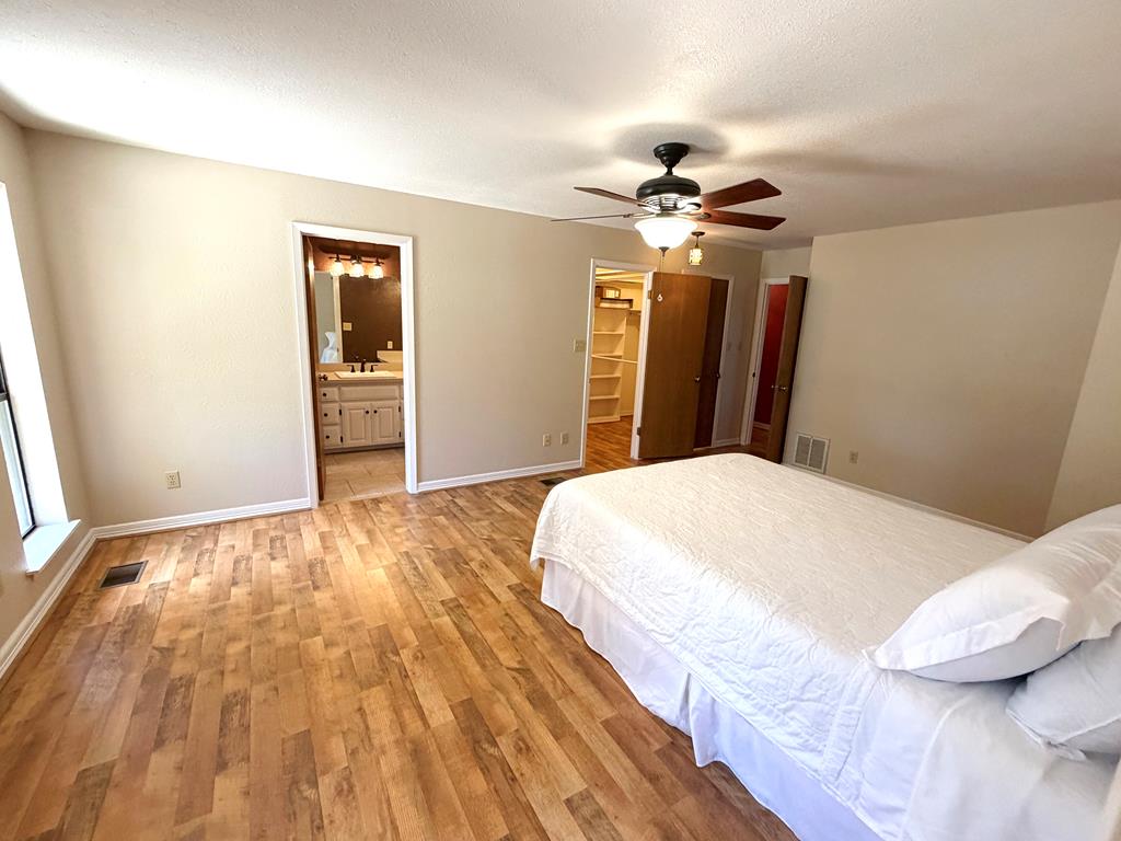 707 Rimrock Road Kerrville, TX 78028 - Photo 28 of 55 a bedroom with a bed and a chandelier