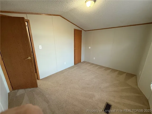 an empty room with closet and mirror