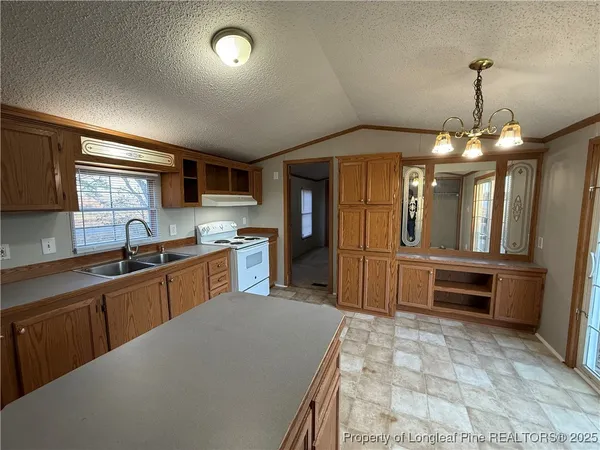 a kitchen with granite countertop a stove and a sink