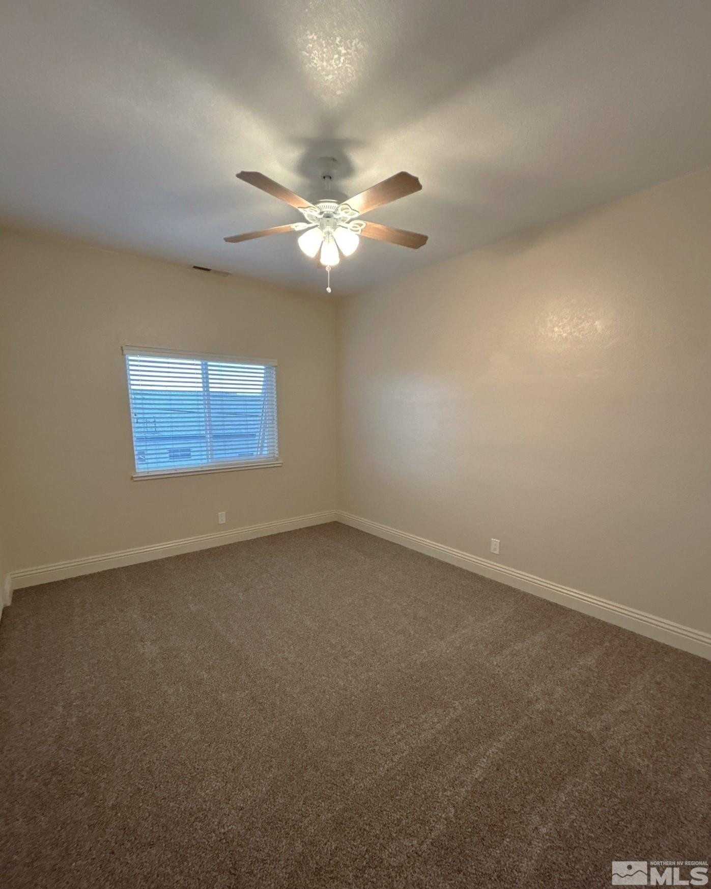 480 Sunshine Lane Reno, NV 89502 - Photo 5 of 11 an empty room with a window and a ceiling fan