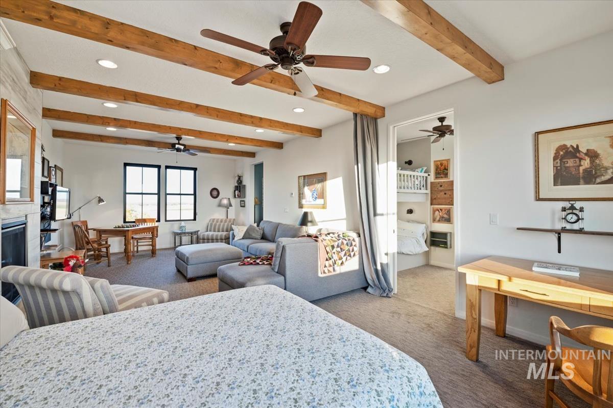 11326 West Rio Road Caldwell, ID 83607 - Photo 30 of 50 Carpeted bedroom featuring beamed ceiling, a glass covered fireplace, recessed lighting, connected bathroom, and an office area