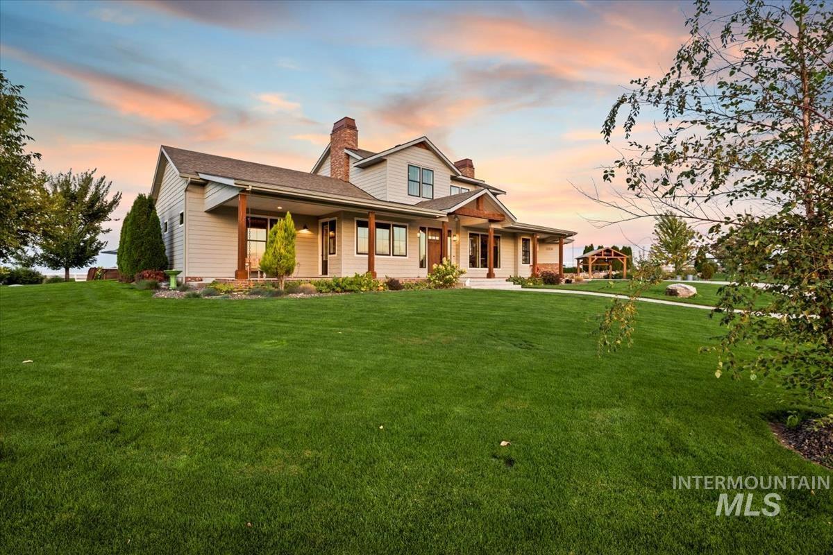 11326 West Rio Road Caldwell, ID 83607 - Photo 33 of 50 View of front of house with a chimney, a porch, and a lawn