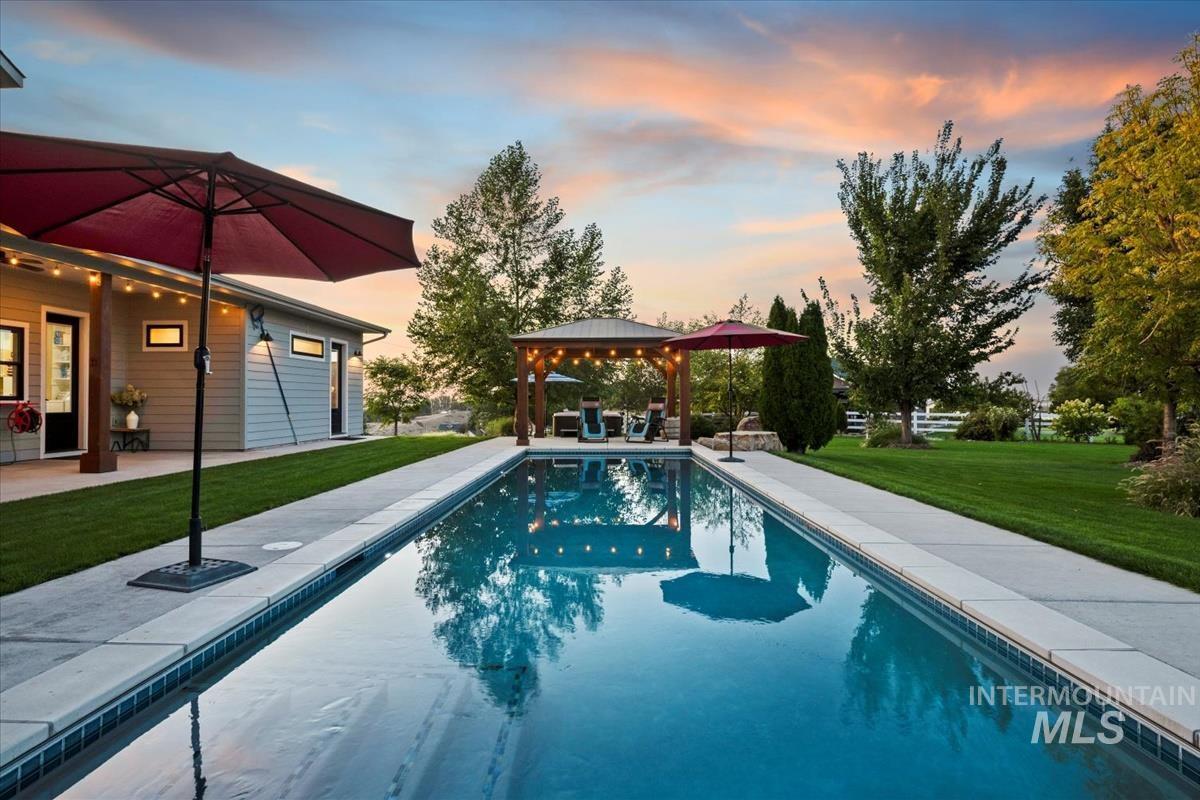 11326 West Rio Road Caldwell, ID 83607 - Photo 35 of 50 Pool at dusk with a lawn, a gazebo, an outdoor pool, and a patio