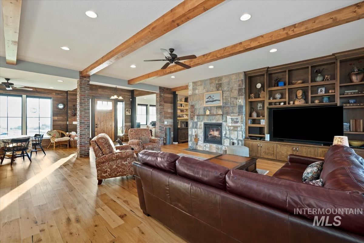 11326 West Rio Road Caldwell, ID 83607 - Photo 7 of 50 Living room featuring ceiling fan, light wood-style floors, recessed lighting, a fireplace, and beamed ceiling