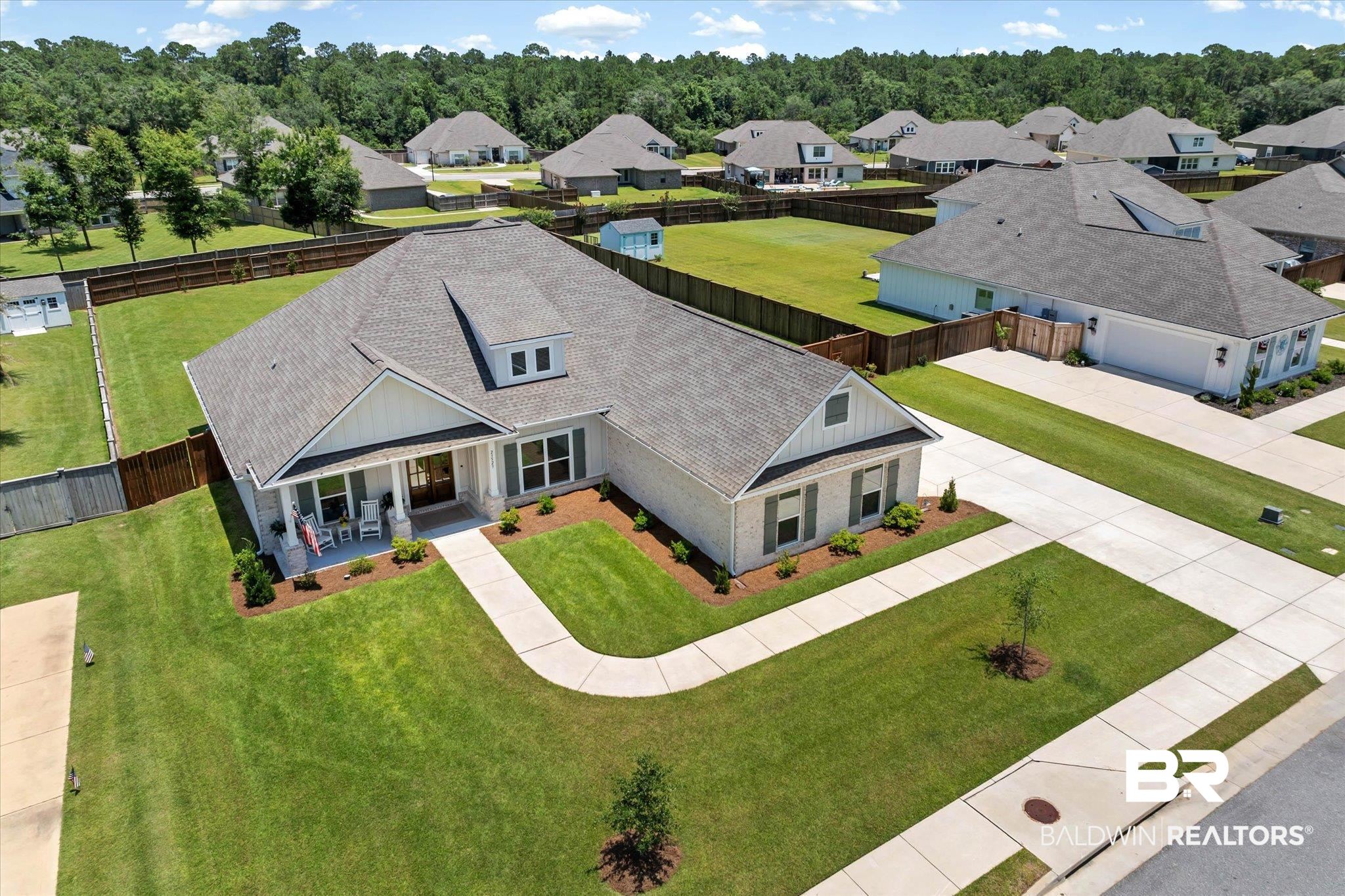 23523 Travis Stock Street Foley, AL 36535 - Photo 34 of 45 Contemporary single-story residence with a light-colored facade, dark shingle roof, and a covered front porch featuring white columns